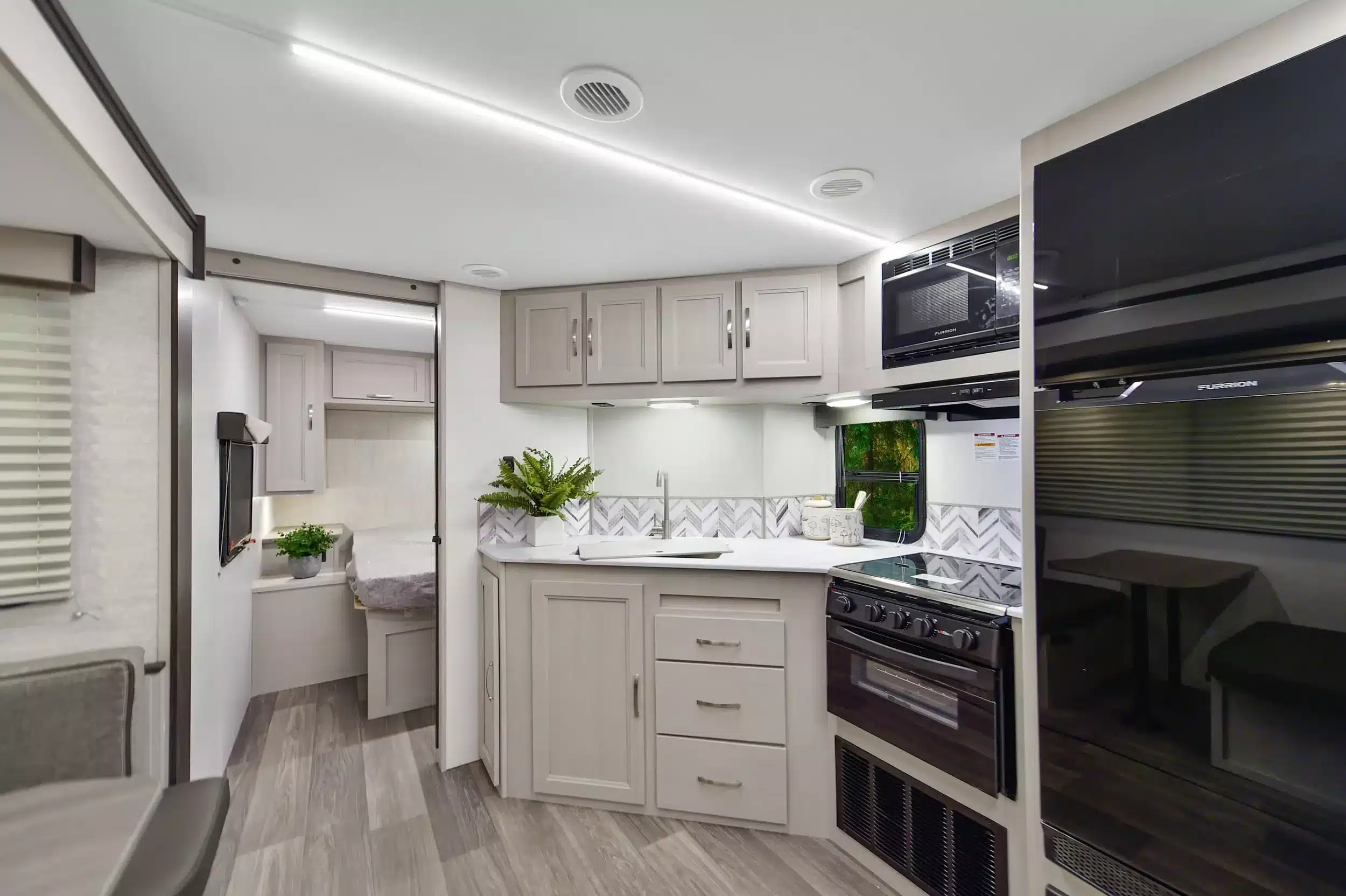 Innenansicht des Shadow Cruiser 261RB mit Küche, Kochfeld, großem Kühlschrank und Blick ins Schlafzimmer.