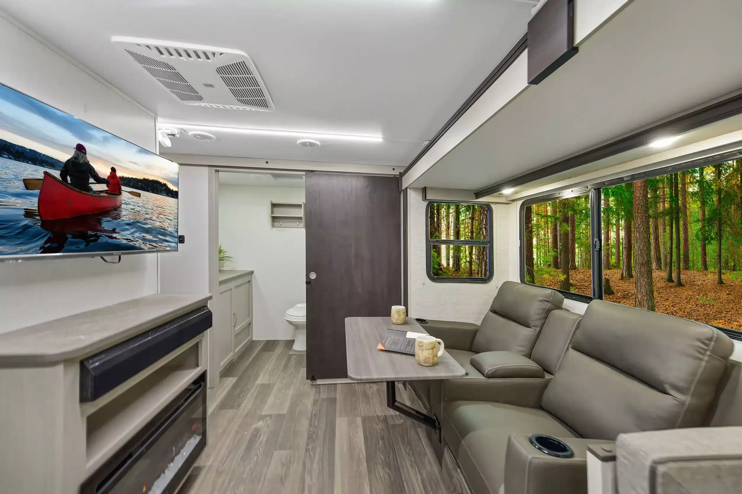 Innenansicht des Shadow Cruiser 261RB mit Sofa, Tisch, großem Fenster und sichtbarem Badezimmer
