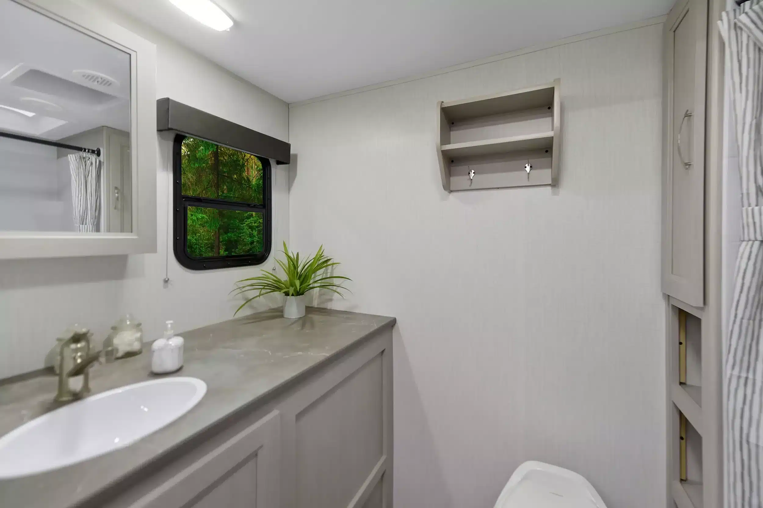 Innenansicht des Badezimmers mit Waschbecken, Fenster und Ablagen im Shadow Cruiser 261RB Wohnanhänger