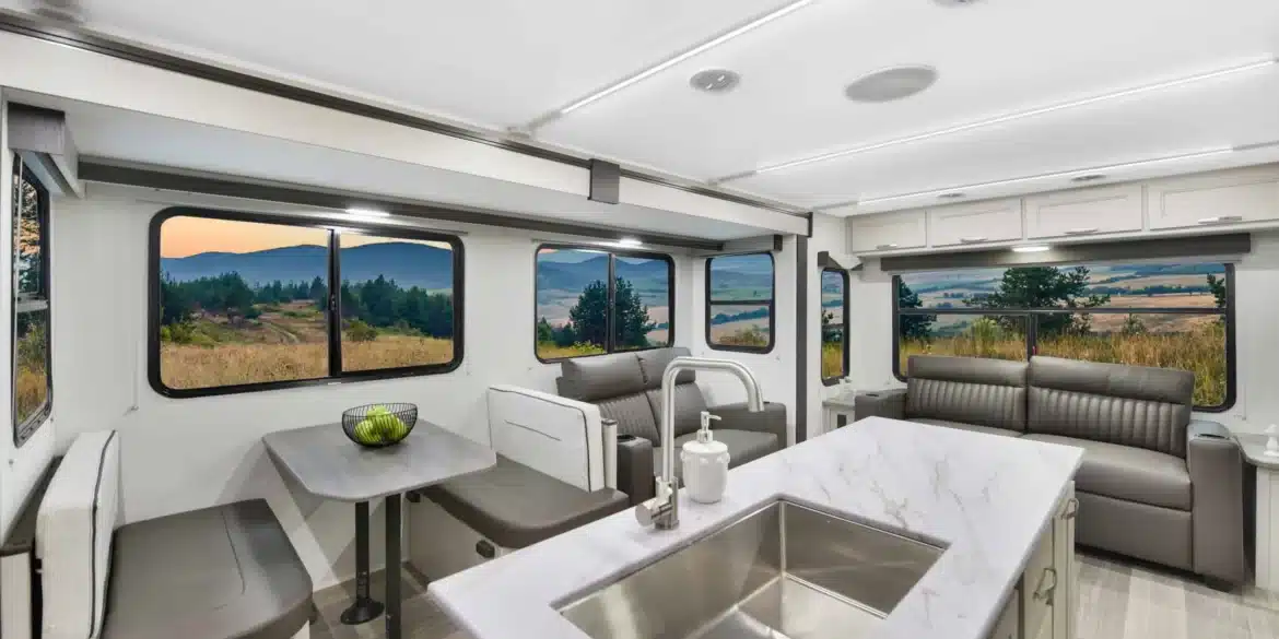 Innenansicht des Shadow Cruiser 300RLS Travel-Trailers mit großzügiger Sitzgruppe, Couch und Kücheninsel