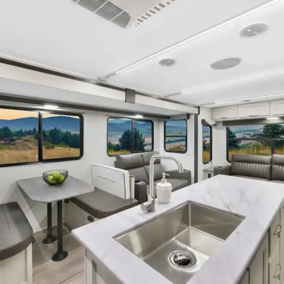 Innenansicht des Shadow Cruiser 300RLS Travel-Trailers mit großzügiger Sitzgruppe, Couch und Kücheninsel