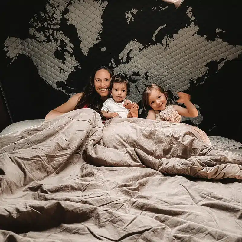 Mutter mit zwei Kindern im Skycamp 2.0 Dachzelt auf großer Liegefläche