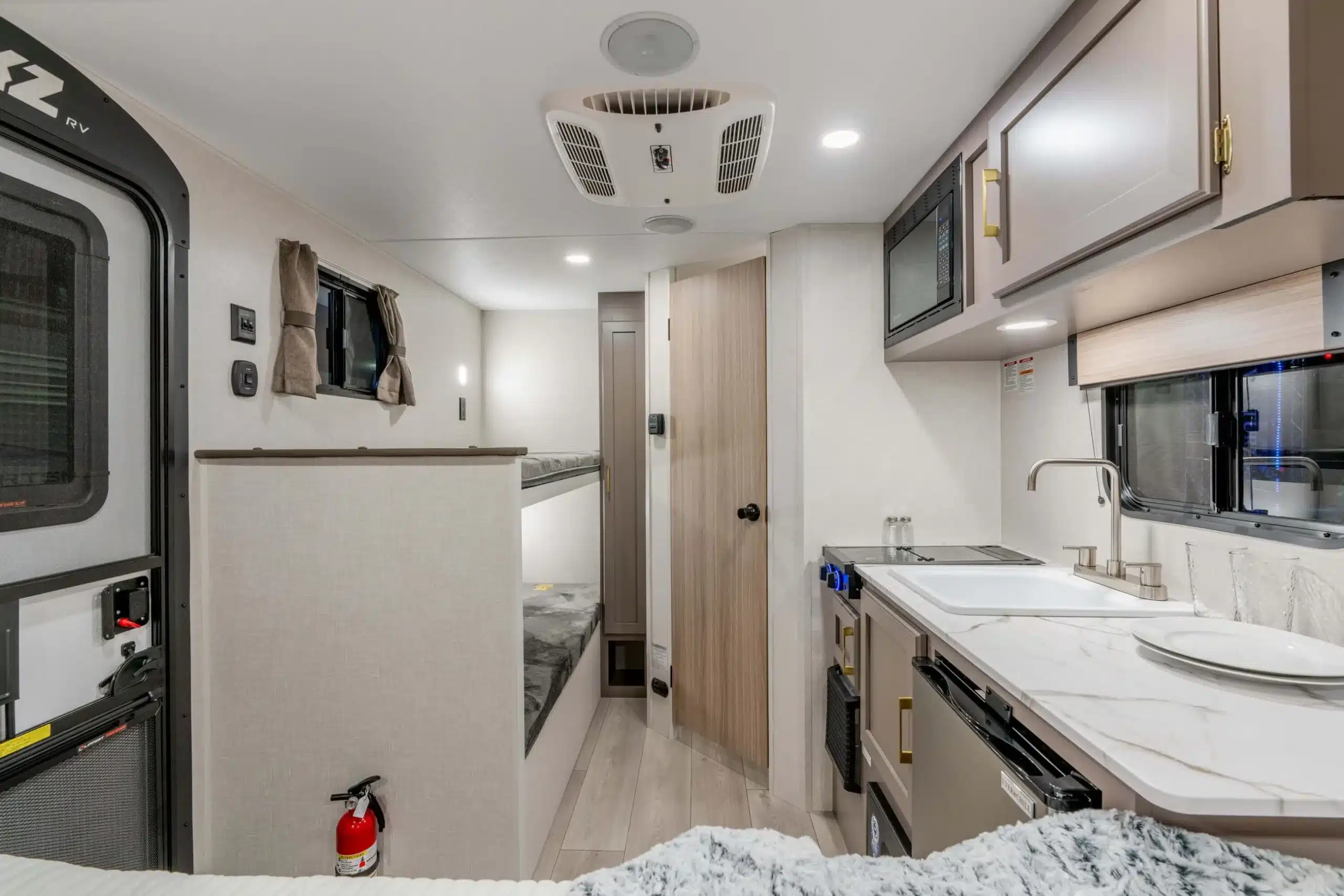 Innenraum eines kompakten Sportsmen Classic Caravans mit moderner Küche, Schlafbereich und Stauraum.