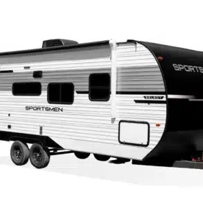 Seitenansicht des US-Travel-Trailers Sportsmen Select mit markanter schwarz-weißer Außenlackierung und zwei Achsen.