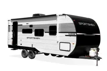 Seitenansicht des US-Travel-Trailers Sportsmen Select mit markanter schwarz-weißer Außenlackierung und zwei Achsen.