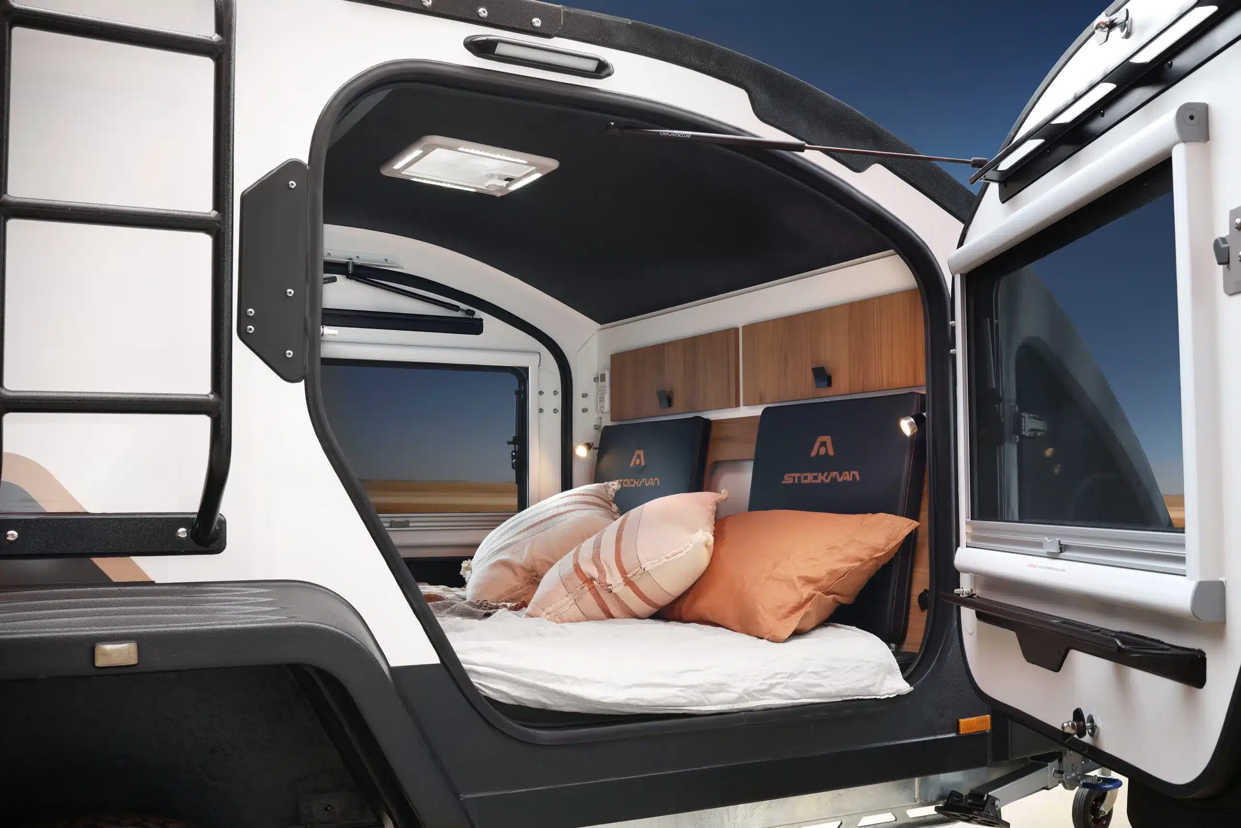Innenansicht der Schlafkabine im Stockman Rover 02 Camper mit Bett, Kissen und Staufächern