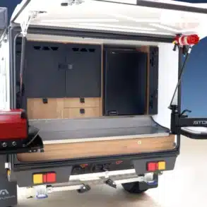 Heckansicht des Stockman Rover 02 Pod-Campers mit aufgeklappter Outdoor-Küche, Bushman-Kühlschrank, grillendem rotem BBQ-Kocher und Spüle.