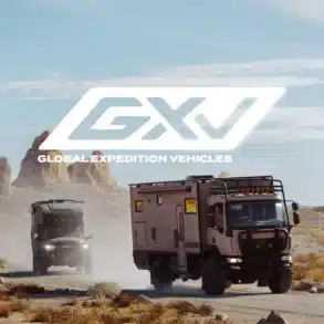 Zwei Expeditionsfahrzeuge von Storyteller GXV fahren auf einer staubigen Straße durch eine felsige Wüstenlandschaft