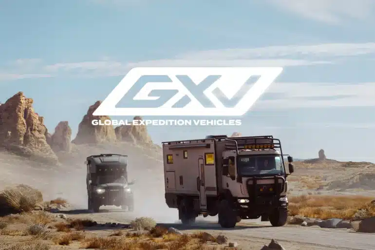 Zwei Expeditionsfahrzeuge von Storyteller GXV fahren auf einer staubigen Straße durch eine felsige Wüstenlandschaft
