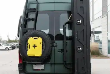Heck von grünem Mercedes Sprinter Campervan mit Offroad-Trägermodulen, Reserverad, Außenleiter und großem Staubox-System