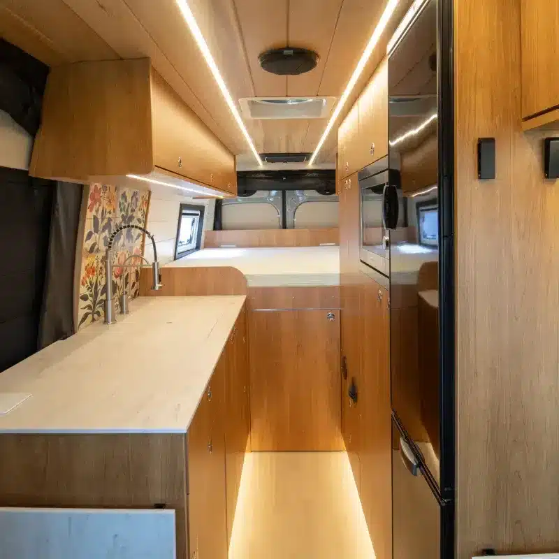 Moderner Innenausbau eines Mercedes Sprinter 170 Campervans mit Küche, Holzverkleidung und Schlafbereich