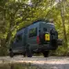 Der grüne Mercedes Sprinter 2500 mit Offroad-Umbau und umfangreichen Trägersystemen in natürlicher Umgebung.