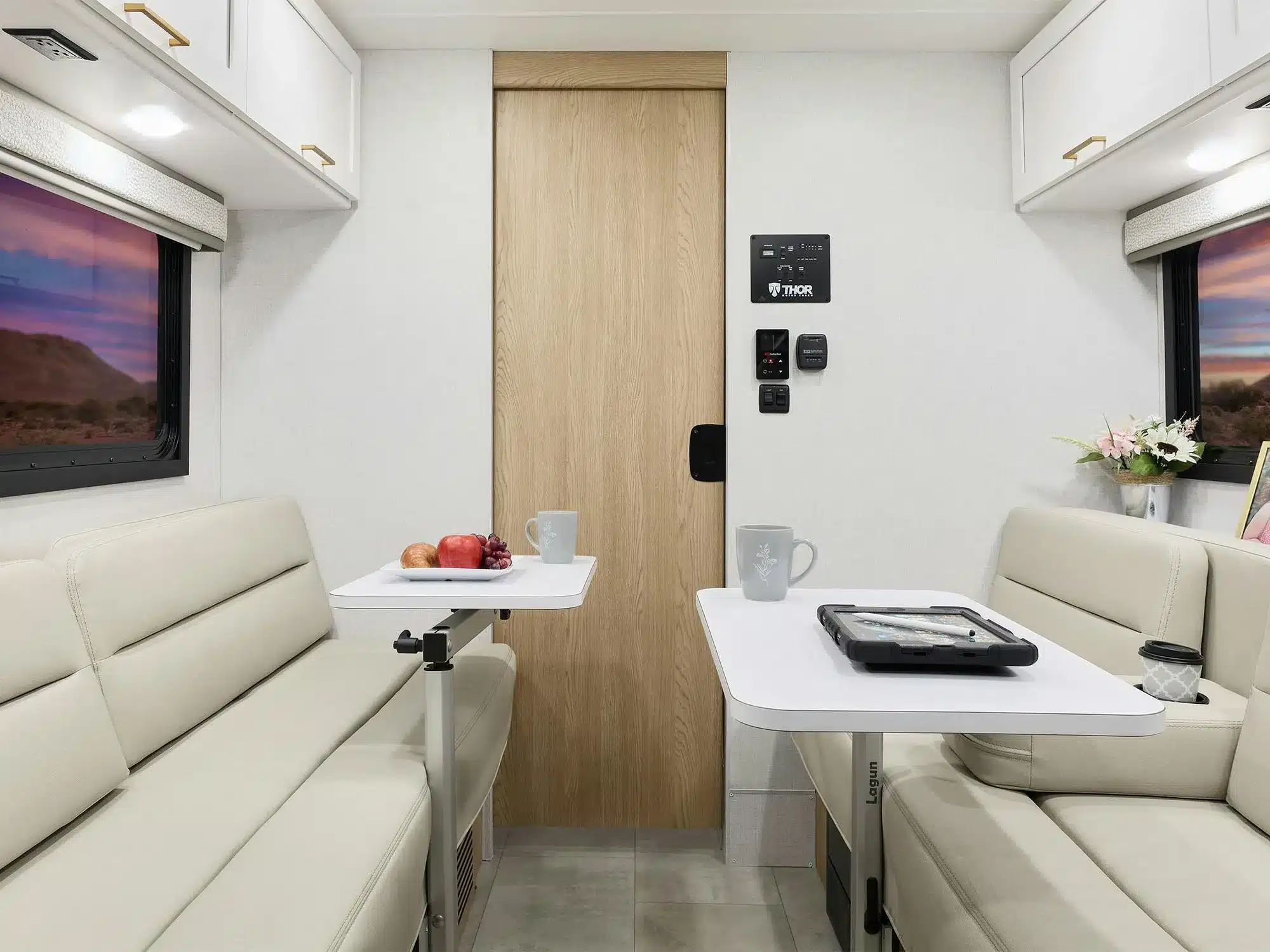 Heller Innenraum eines Thor Chateau Class-C-Motorhomes mit Sitzgruppe und zwei Esstischen.