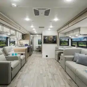 Innenansicht des Thor Hurricane 2026 Reisemobils mit großzügigem Wohnbereich, Küche, Sofas und Esstisch.