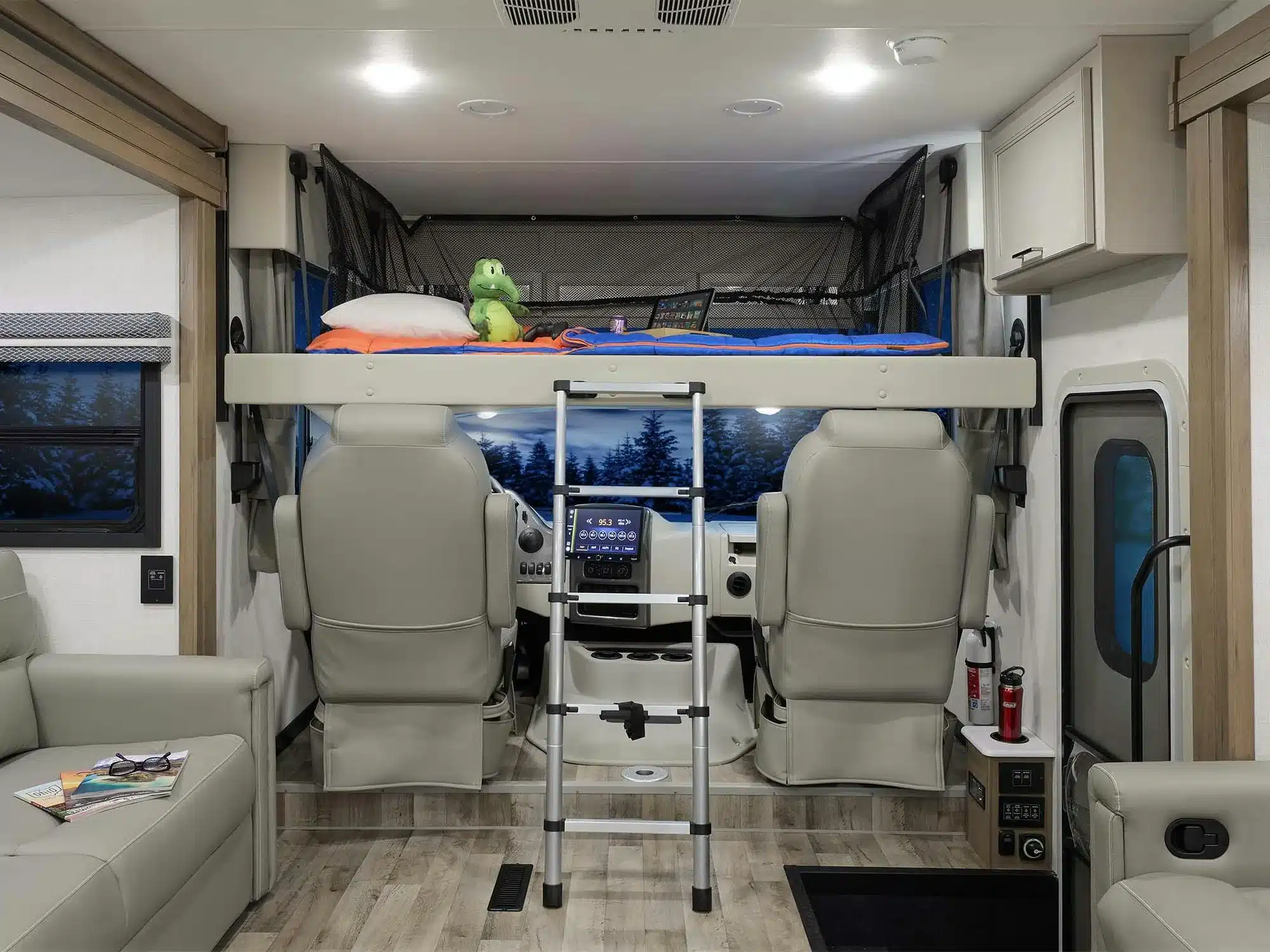 Innenansicht eines Thor Hurricane 2026 Motorhomes mit Hubbett über den Vordersitzen, Leiter und modernem Wohnbereich.