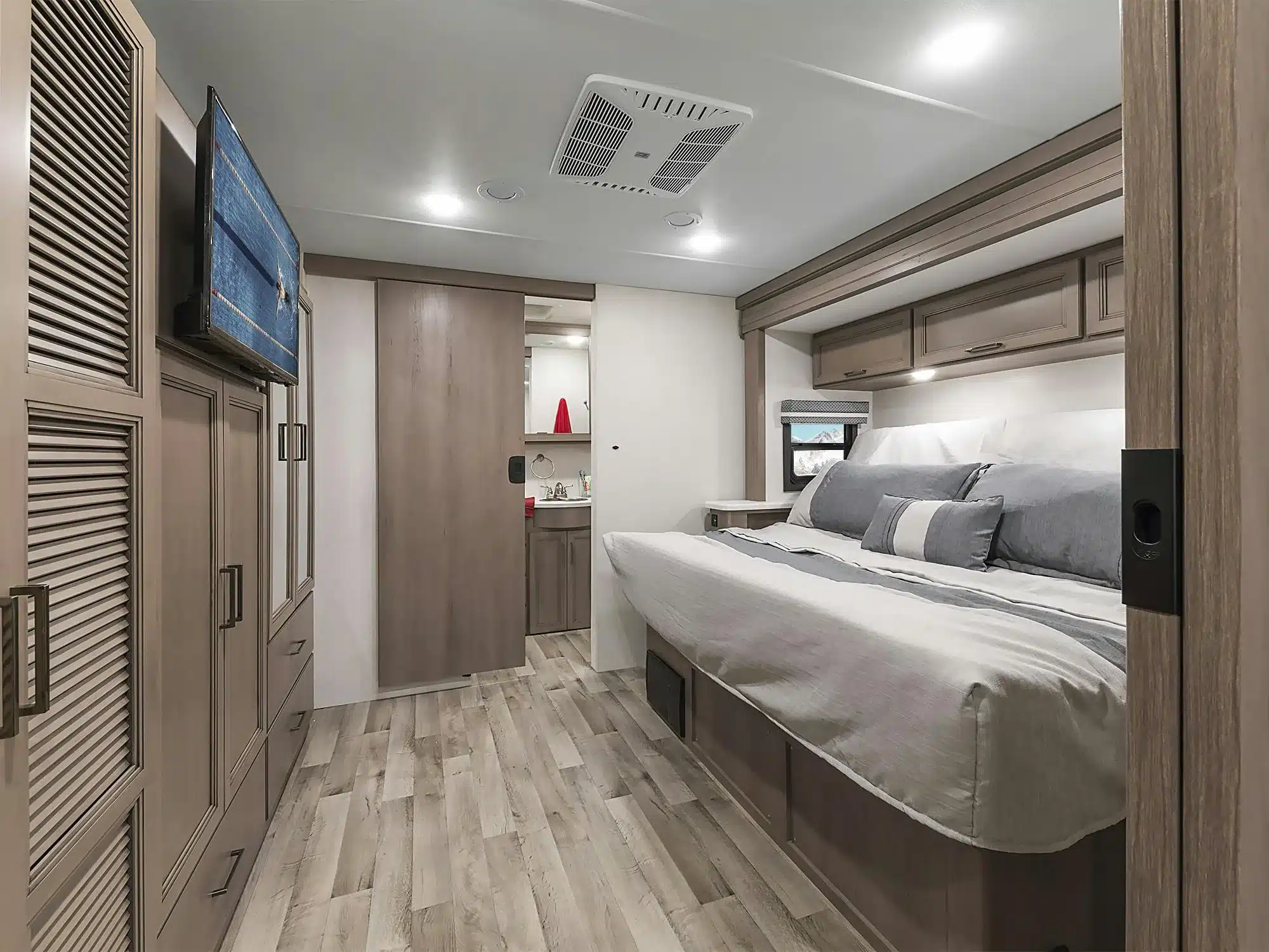 Innenansicht des Schlafzimmers im Thor Hurricane 2026 Reisemobil mit Doppelbett, Schränken und Fernseher.
