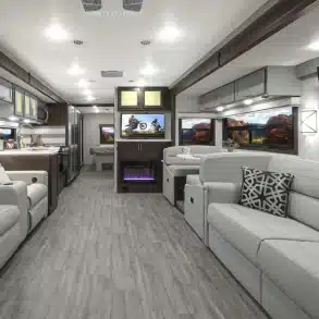Innenansicht des Thor Indigo Class-A-Motorhomes mit Sofa, Dinette, Theater-Sitzen und modern ausgestatteter Küche.