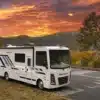 Thor Resonate 2026 Class-A-Motorhome auf Parkplatz vor Sonnenaufgang und herbstlicher Landschaft