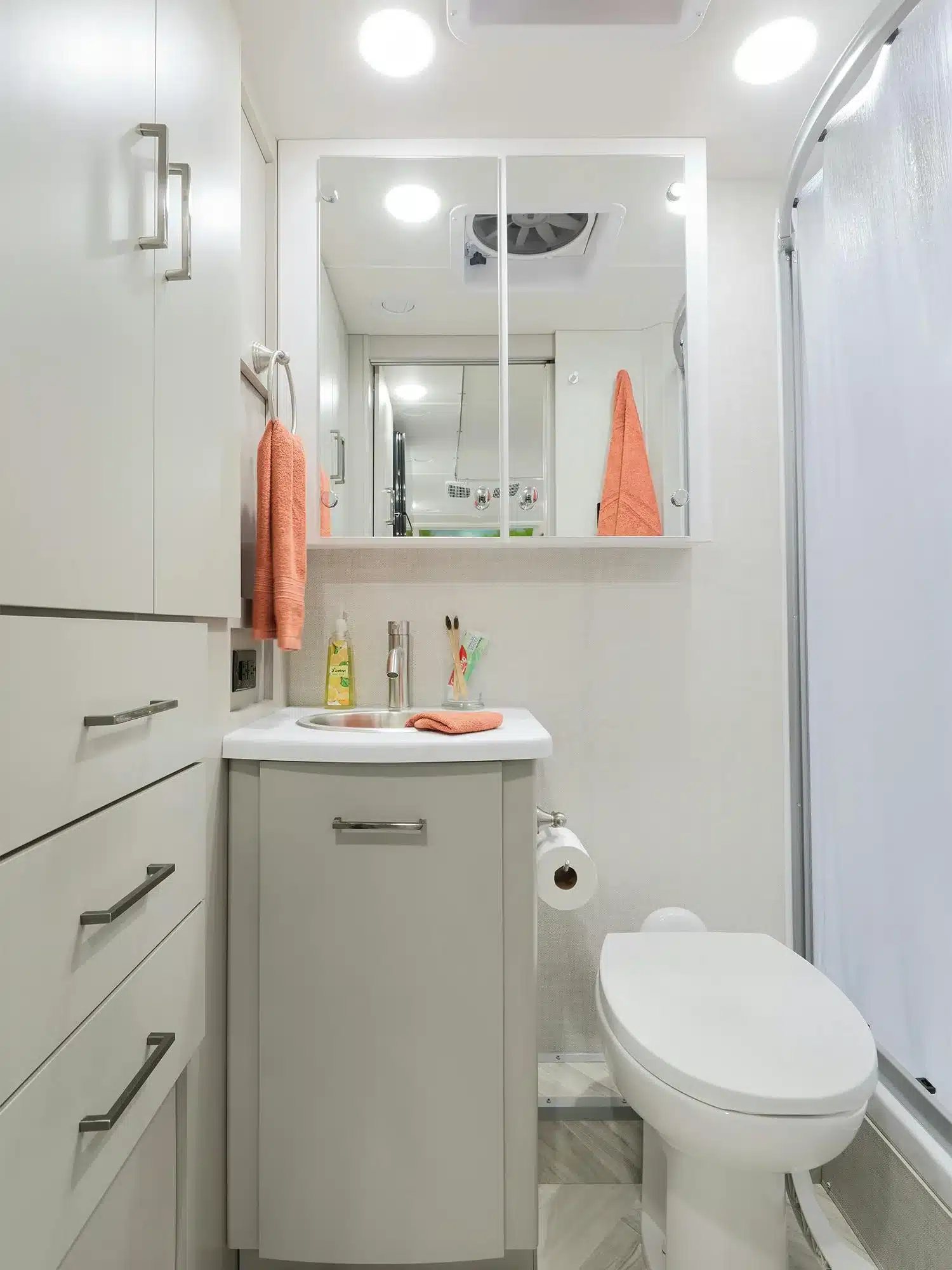 Modernes Wohnmobil-Bad mit Duschkabine, Waschbecken, Spiegelschrank und Toilette im Thor Tiburon 24FB.