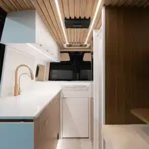 Innenraum eines ausgebauten Kastenwagens mit Küchenzeile, Stauraum und Bett im Thousand Islands Camper.