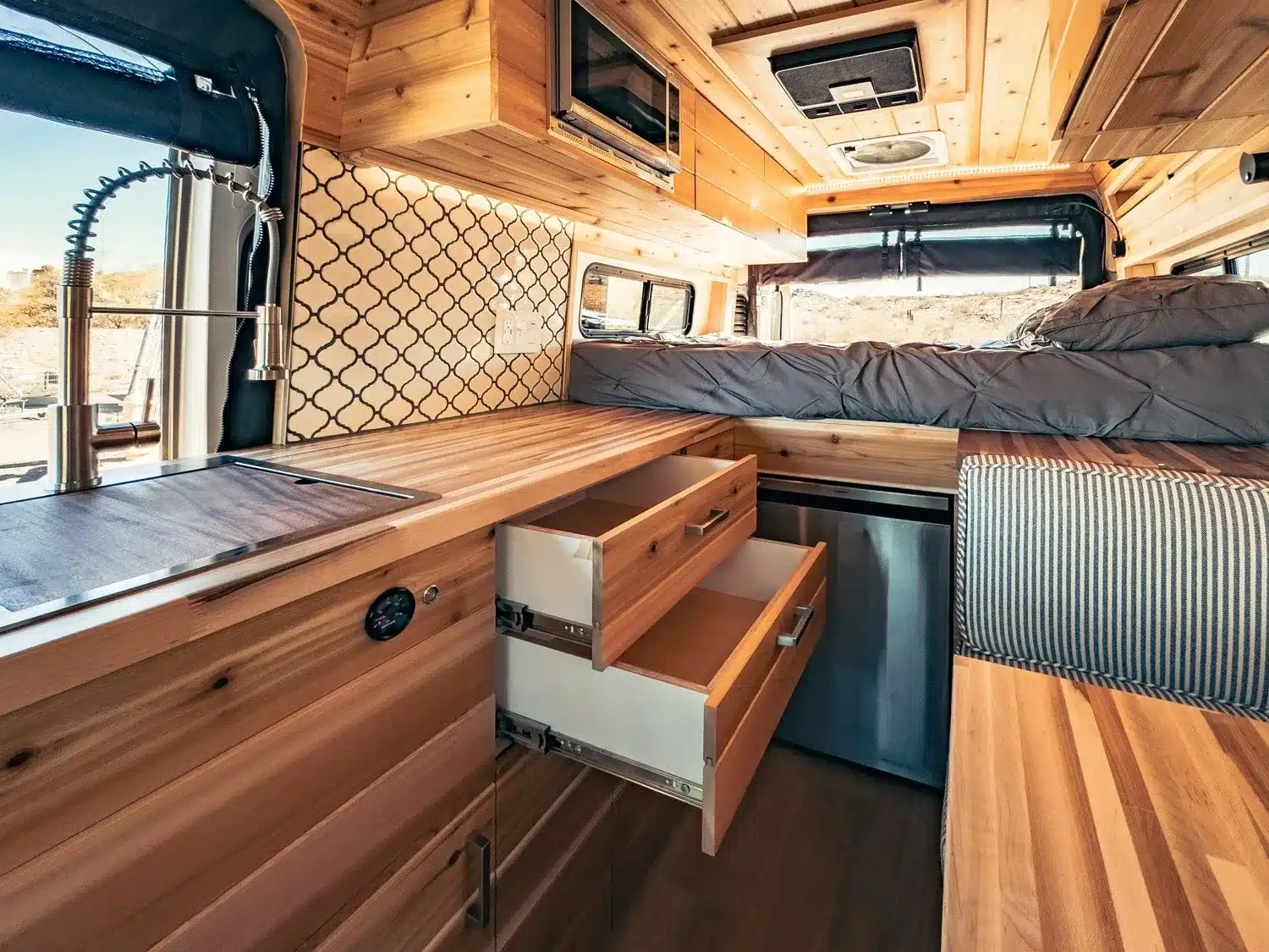 Holzverkleideter Innenraum des Vandiamo Camper Vans mit Küche, Bett und Stauraum