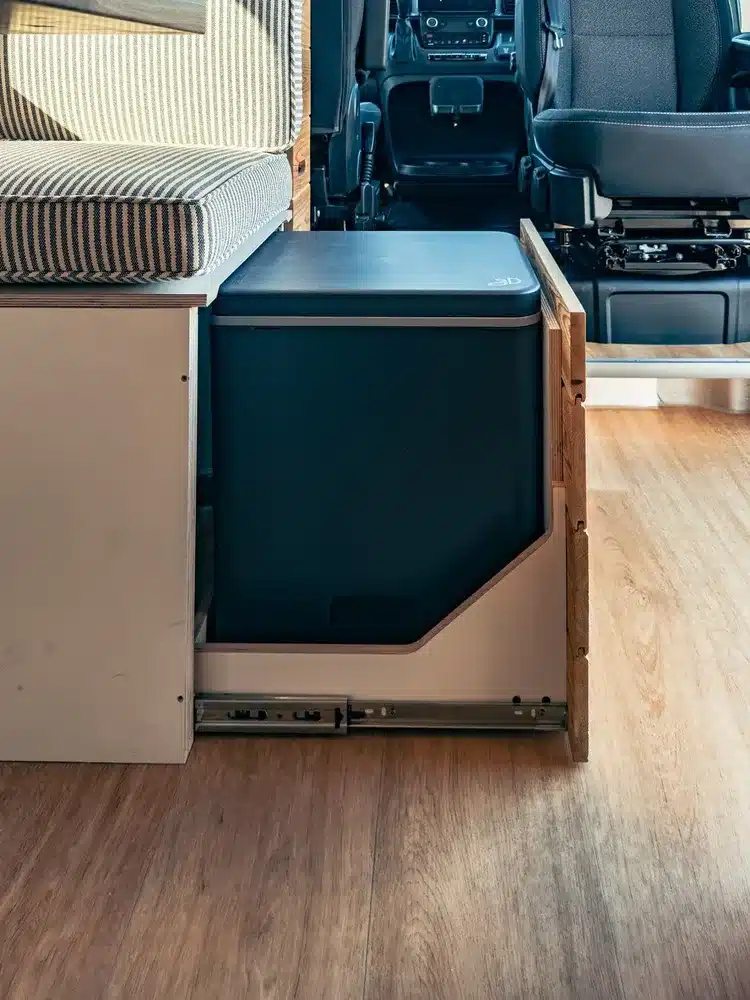 Herausziehbare Kühlbox unter einer Sitzbank im Innenraum eines Vandiamo Kastenwagen-Campers