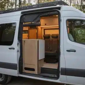 Geöffnete Schiebetür eines Waterton Campervans mit sichtbarer Sitzbank und Küchenmodul