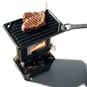 Winnerwell Petroleum Feuerkocher mit gusseiserner Grillplatte und gegrilltem Steak, Flamme sichtbar
