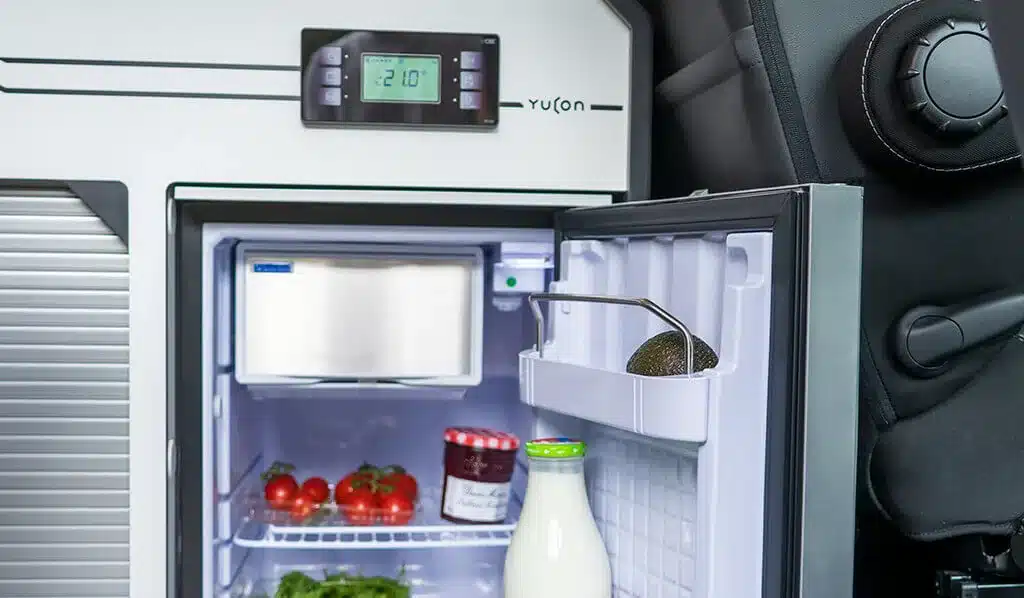 Offener Kühlschrank mit Lebensmitteln im Yucon 55 SB FEVER Campervan.