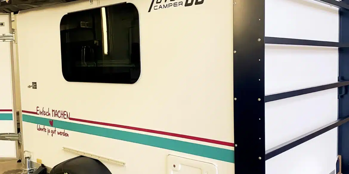 Seitenansicht des 7even50 Mini-Travel Campers mit Markise in einer Garage.