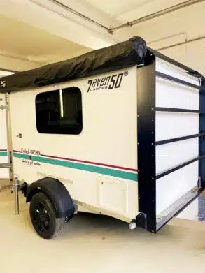 Seitenansicht des 7even50 Mini-Travel Campers mit Markise in einer Garage.