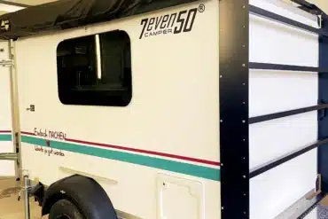 Seitenansicht des 7even50 Mini-Travel Campers mit Markise in einer Garage.