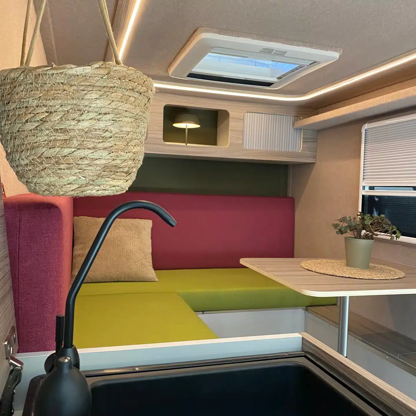 Sitz- und Schlafbereich mit Tisch und Küchenzeile im 7even50 Mini-Travel Mini-Wohnwagen