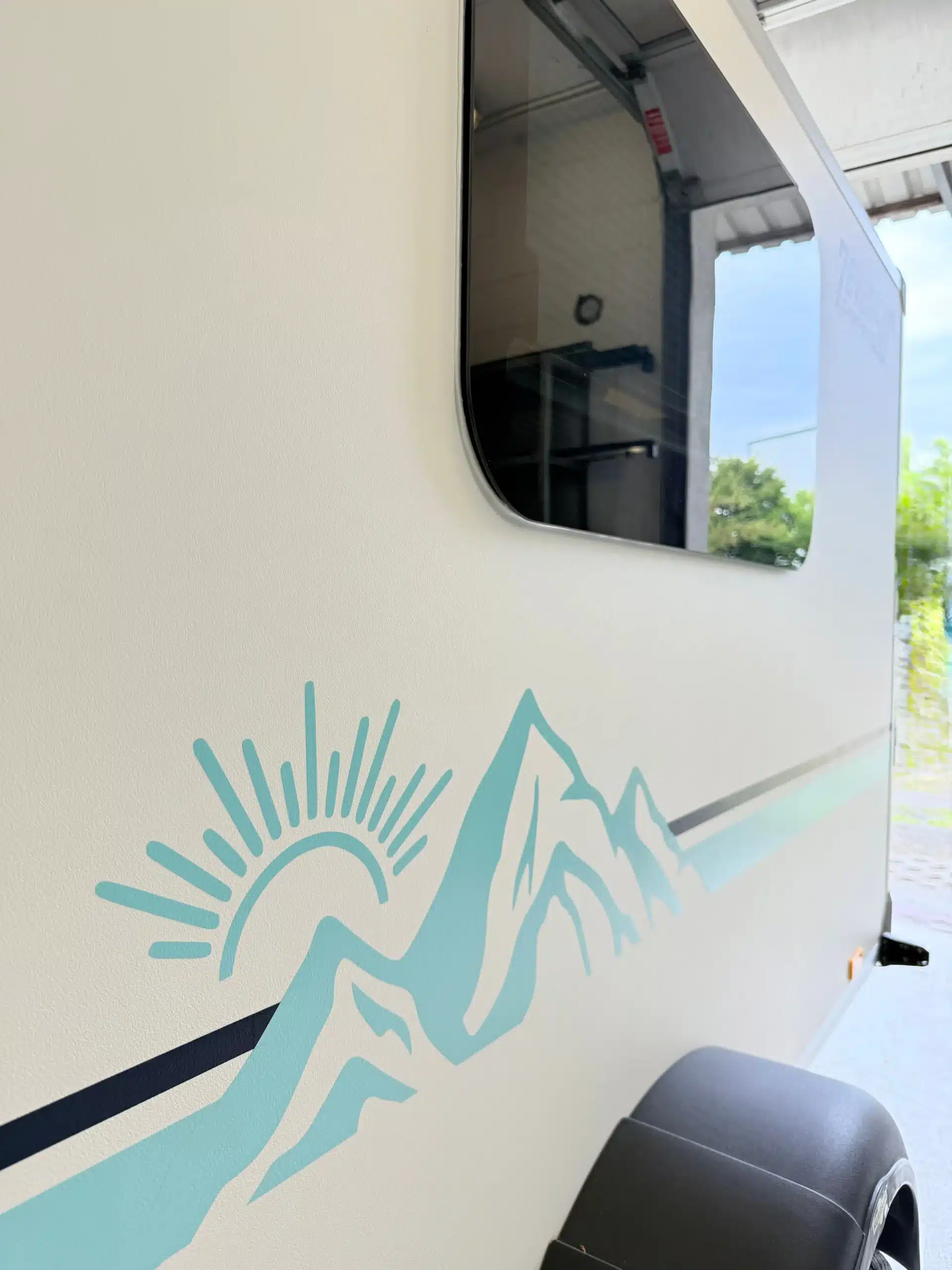 Detail der Seitenwand des 7even50 Mini-Travel mit getöntem Fenster und türkisfarbenem Bergmotiv
