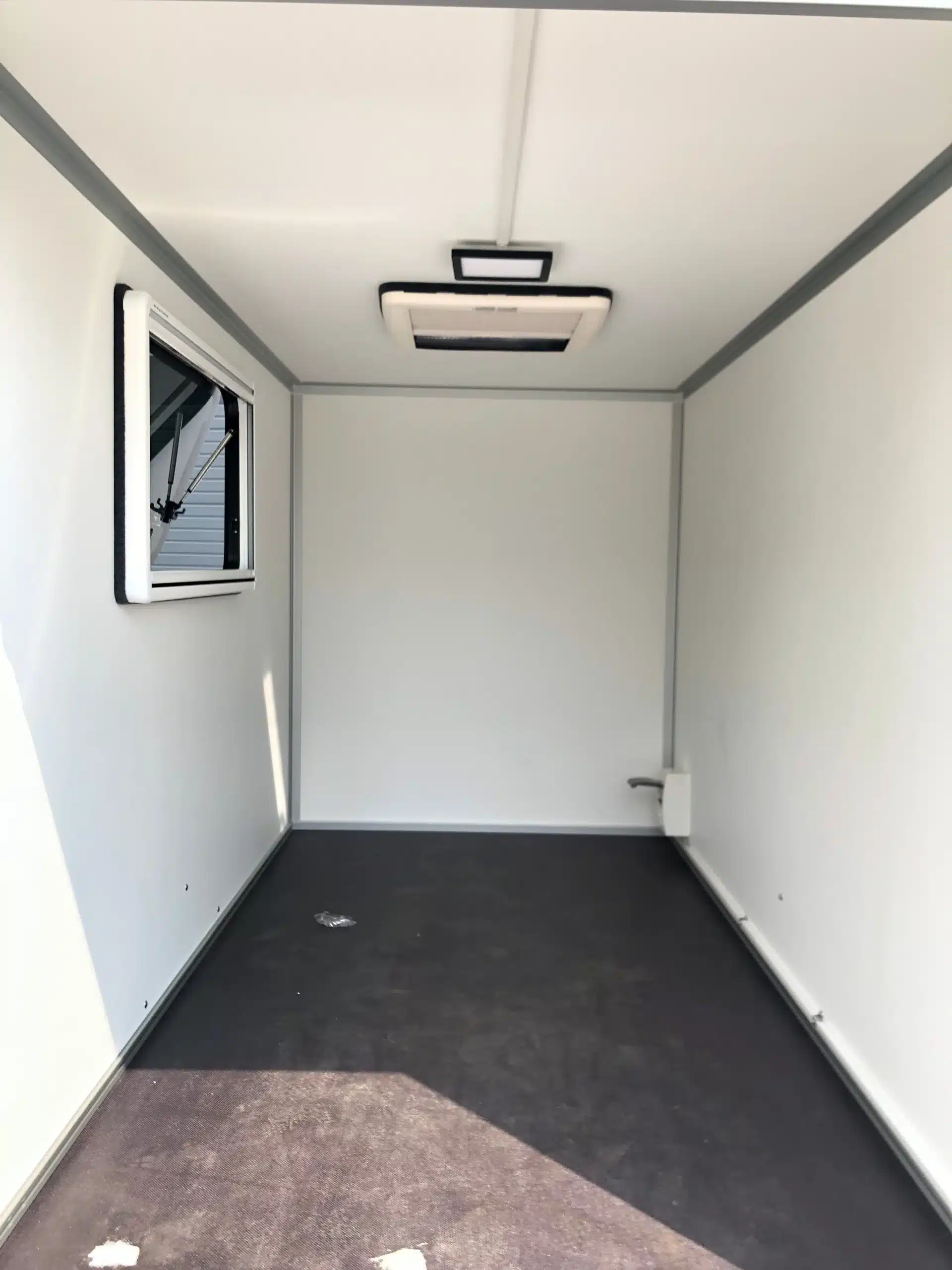 Leerer Innenraum eines 7even50 Two Mini-Camper-Anhängers mit Fenster und Dachluke