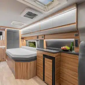 Innenansicht des Affinity Duo Campervan mit komfortablem Bett, Küchenzeile, Bad und Stauraum, ausgelegt für zwei Personen