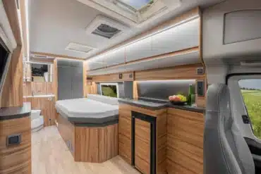 Innenansicht des Affinity Duo Campervan mit komfortablem Bett, Küchenzeile, Bad und Stauraum, ausgelegt für zwei Personen