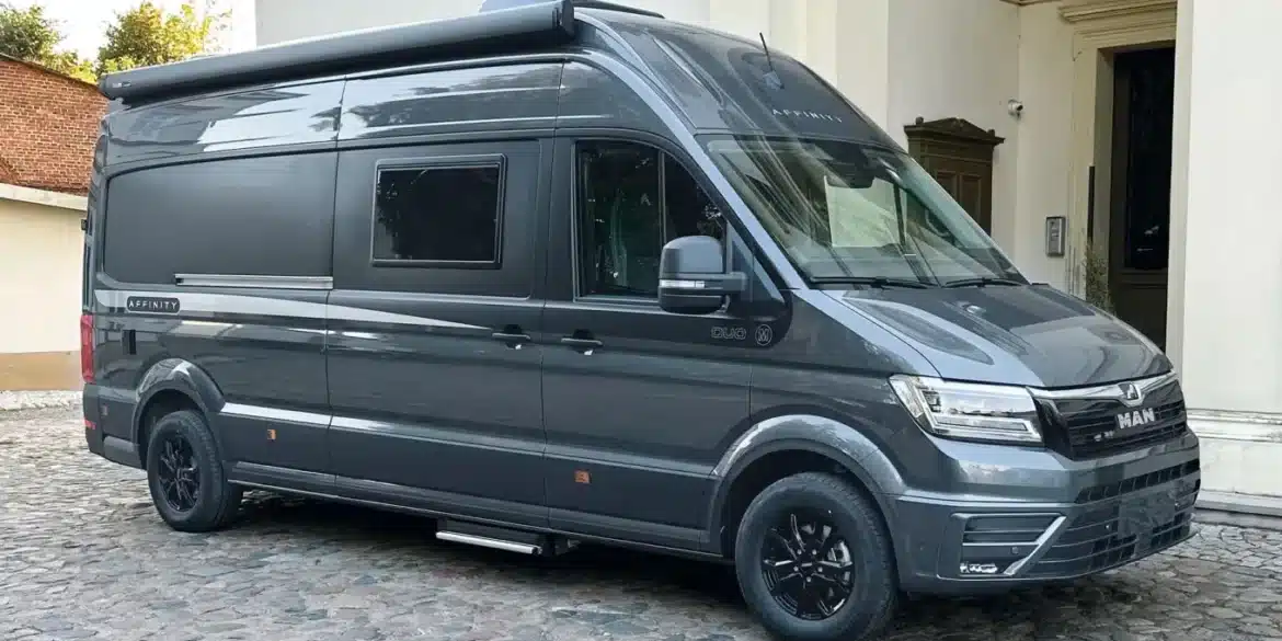 Seitenansicht eines grauen Affinity DUO M Kastenwagens auf MAN TGE Basis vor einem Gebäude, geeignet für komfortables Reisen zu zweit.