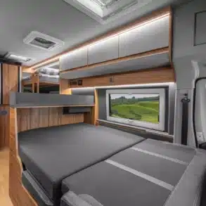Innenansicht eines Affinity Five Campervans mit dreistufigem Etagenbett und großzügigem Wohnraum.