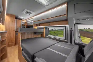 Innenansicht eines Affinity Five Campervans mit dreistufigem Etagenbett und großzügigem Wohnraum.