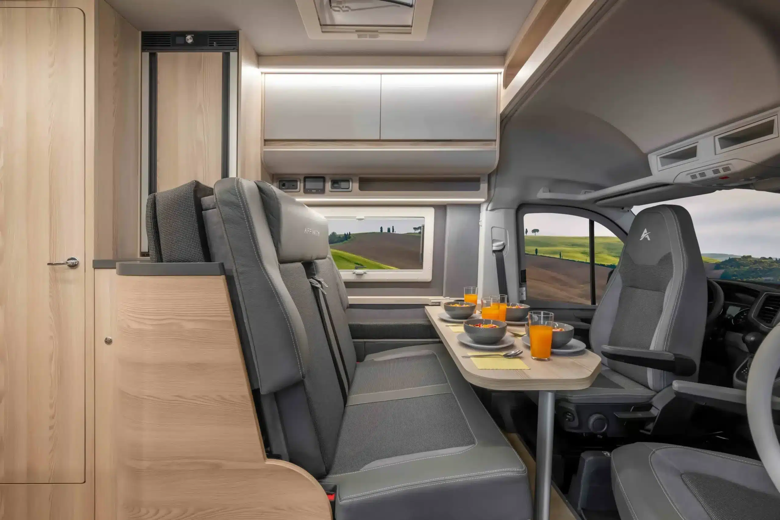 Wohnbereich des Affinity M Four mit Sitzgruppe, Tisch und Fahrerhaus