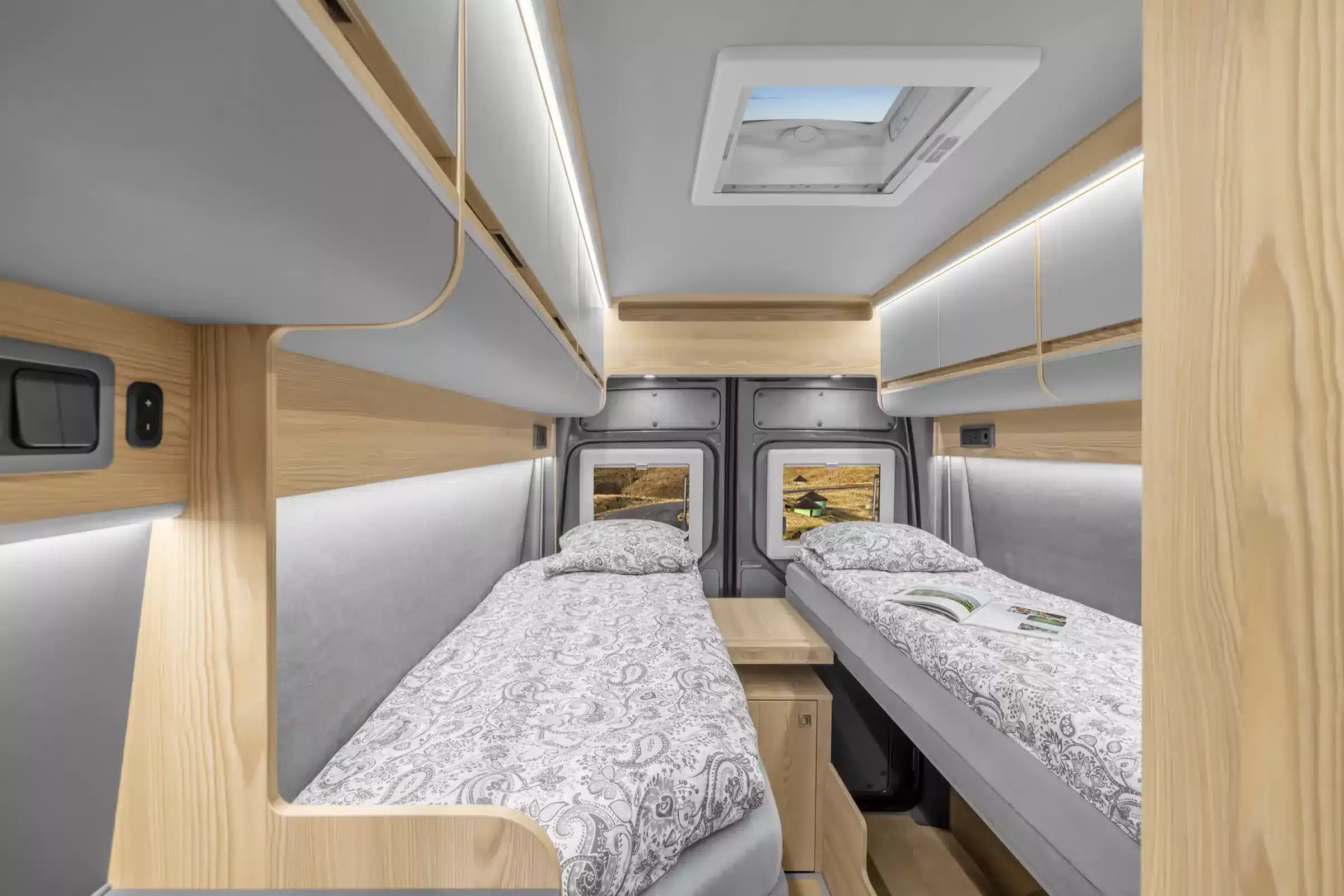 Heckbereich des Affinity M Three mit zwei Einzellängsbetten, modernen Hängeschränken und Dachfenster