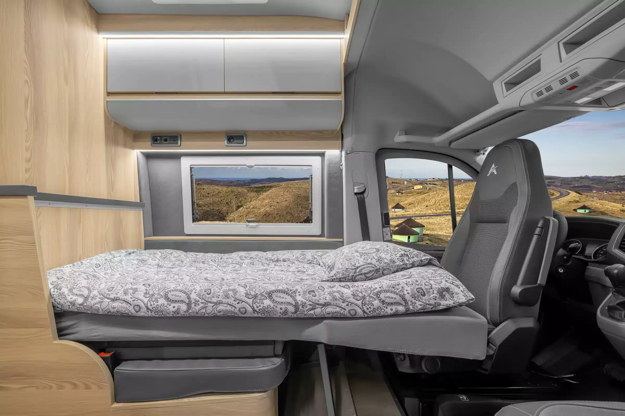 Innenraum mit Einzellängsbett und Cockpit im Affinity M Three Camper auf MAN-Basis