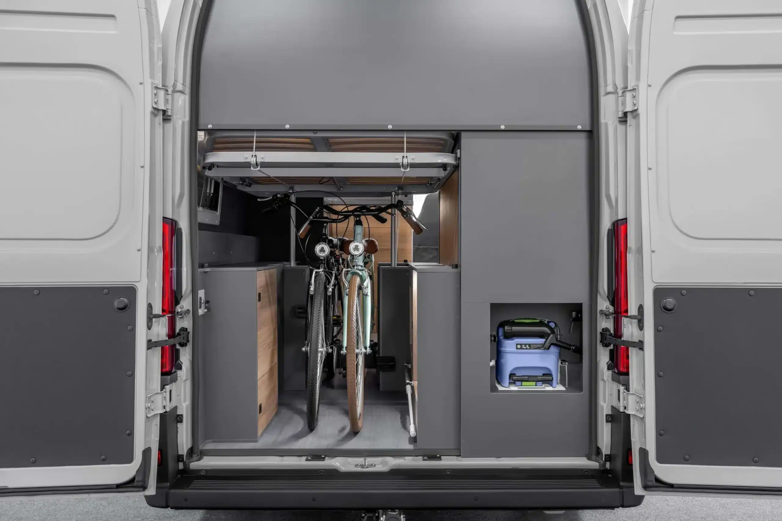 Blick in den Heckstauraum des AFFINITY ONE Campervans mit zwei Fahrrädern und praktischem Staukonzept.