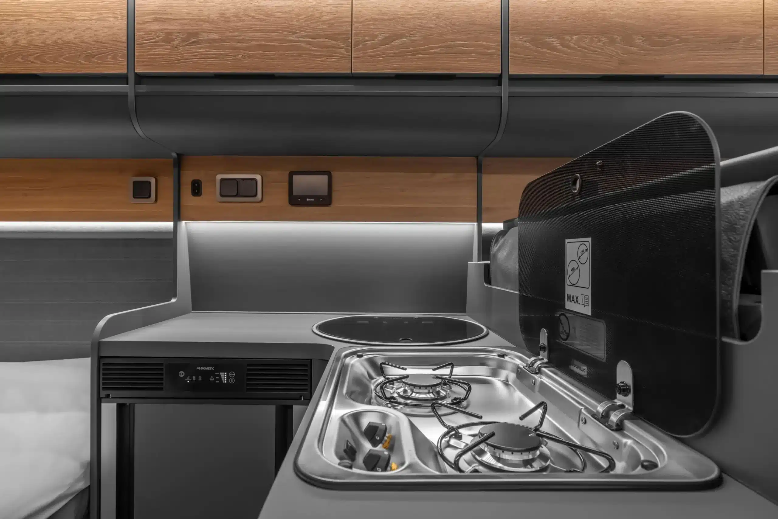 Detailansicht der modernen L-Küche im AFFINITY ONE Campervan mit Gasherd und Kühlschrank.