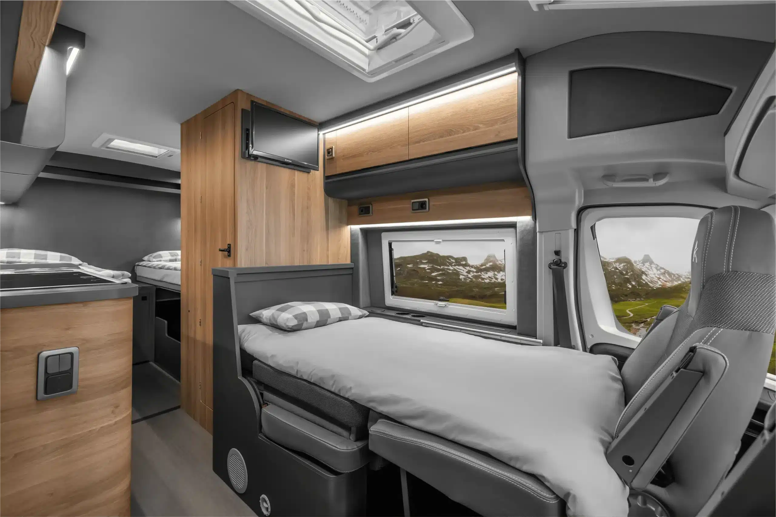Blick in den Innenraum des Affinity Three Kastenwagens mit mehreren Betten, Holzdekor und Fenster, geeignet für Familienreisen