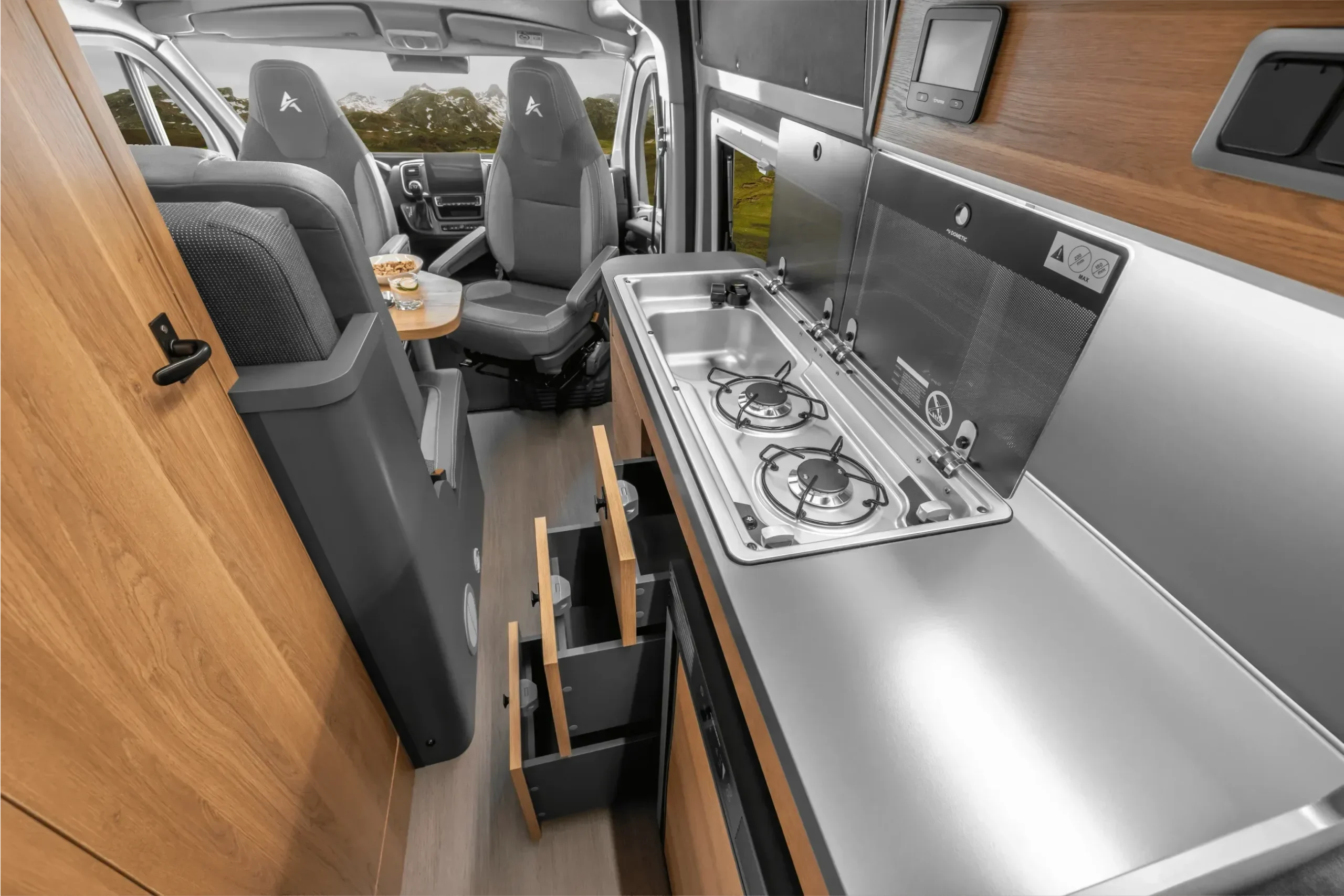 Küchenbereich mit Gasherd, Spüle und Sitzgruppe im Affinity Three Kastenwagen.