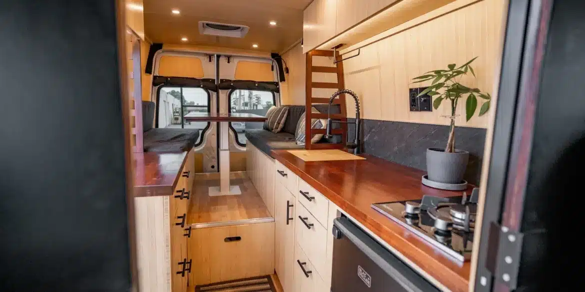 Individuell ausgebauter Camper-Innenraum mit Bambus, Küchenblock, Tisch und Sitzplätzen, Design inspiriert von japanischer Teehaus-Architektur