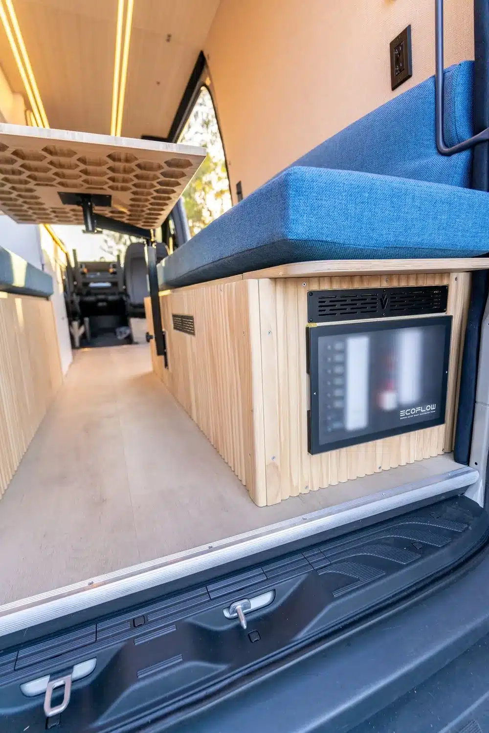 Modularer Innenausbau im Base Camp 2 Van mit blauer Sitzbank, Holzverkleidung und EcoFlow Power-Kit
