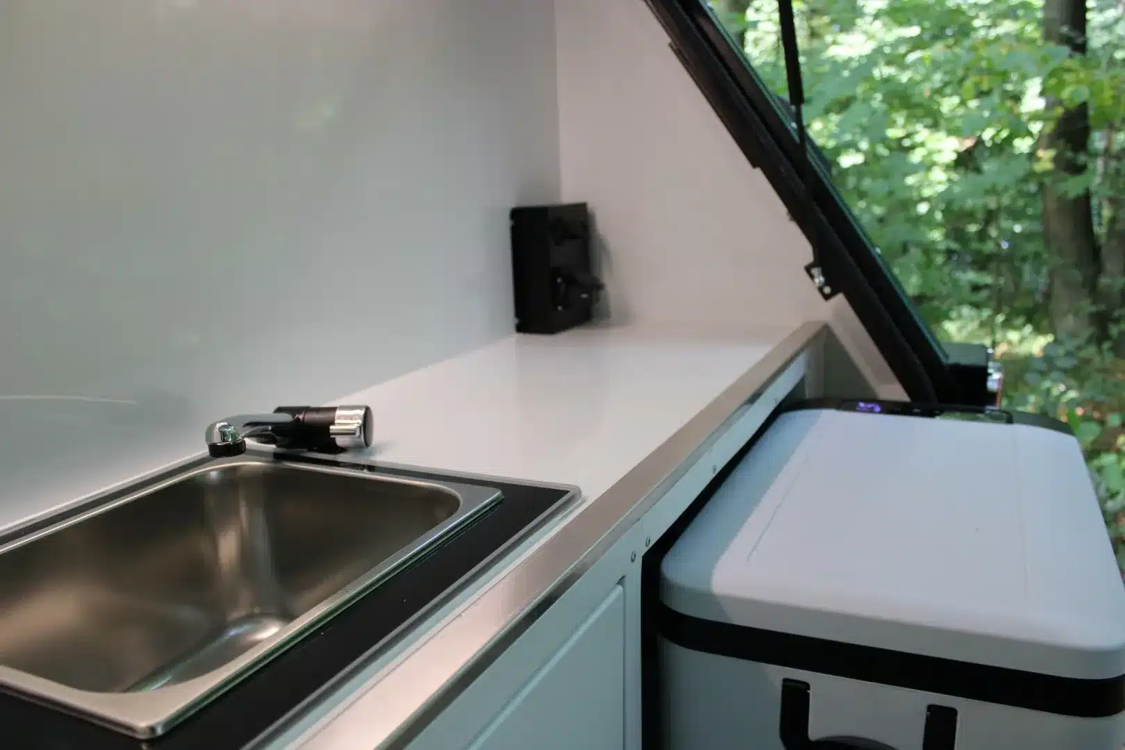 Moderne Outdoor-Küchenzeile mit Edelstahlspüle und Kühlbox im Camppass CR400 Journey